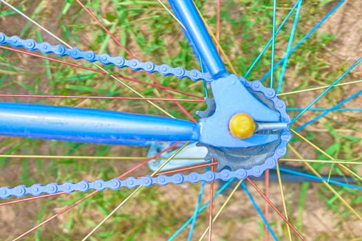 Bright blue bike lying on the grass with sand on a Sunny day