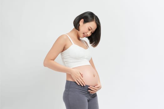 pregnant woman holding her belly on wite background