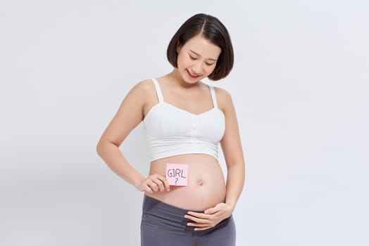 Pregnant woman with paper stickers on tummy, closeup.