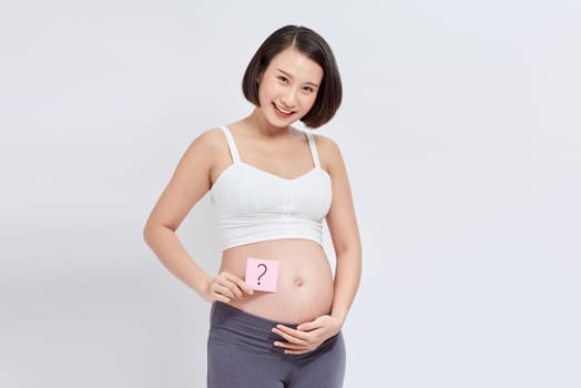 Pregnant woman with a sticky note, which is drawing a question sign, on her belly