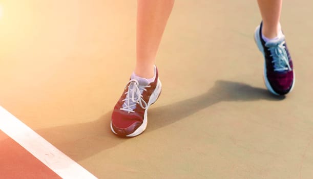 Legs of young girl in a closed tennis court with racket