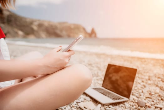 Woman sea laptop. Business woman in yellow hat working on laptop by sea. Close up on hands of pretty lady typing on computer outdoors summer day. Freelance, digital nomad, travel and holidays concept