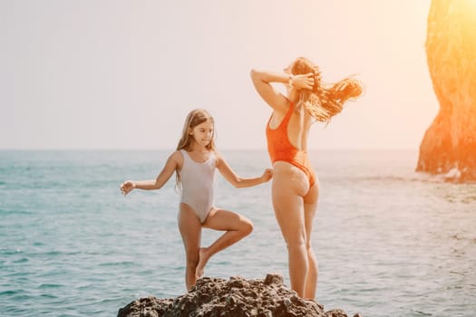 Silhouette mother and daughter doing yoga at beach. Woman on yoga mat in beach meditation, mental health training or mind wellness by ocean, sea