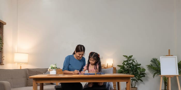 Mother and her daughter draw in the paper together, Leisure activities, holiday.