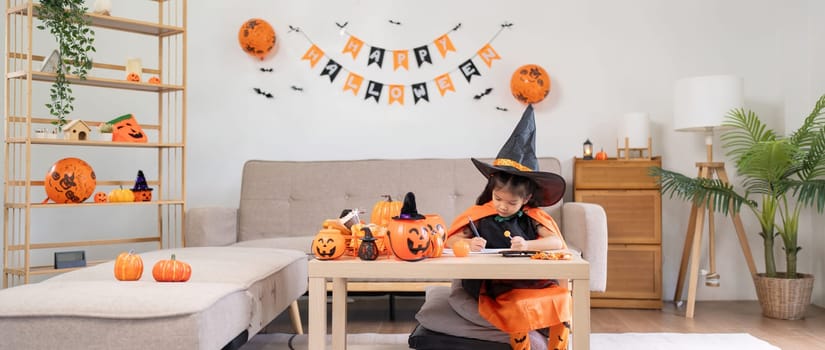 Halloween concept cute little child girl preparing to celebrate at home.