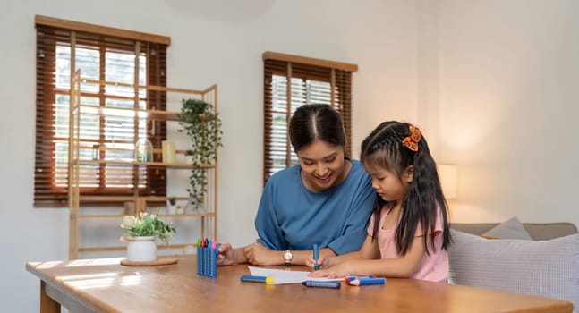 Mother and her daughter draw in the paper together, Leisure activities, holiday.