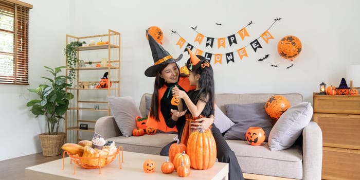 Happy family mother and child happy girl with Halloween at home together beautifully decorated.