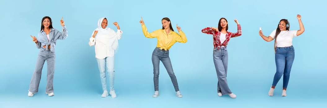 Smiling millennial diverse women in wireless headphones dancing, have fun with phone, enjoy fun, isolated on blue studio background, panorama, full length. Relax, lifestyle, ad and offer