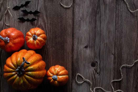 Top view Halloween concept Pumpkin decorations and black paper bat flying over the wooden floor..