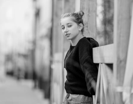 Beautiful teenager girl posing in park outdoors at nature. Pretty teen model in trendy clothes at street portrait