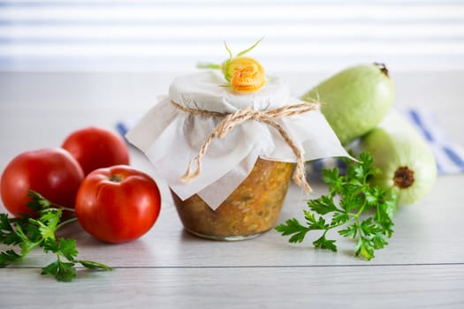 Cooked zucchini caviar with tomatoes in a glass jar, preservation.