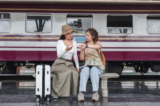 Two young female tourists are stressed when their train trip is delayed..