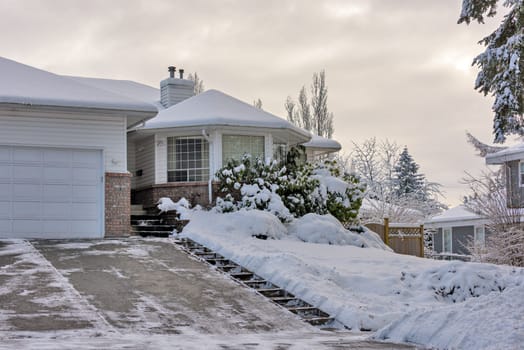 Big residential house with rotonda in snow on overcast winter day.
