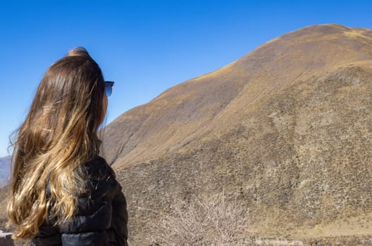 Blonde woman enjoying nature.Background for tourism ads.Winter Adventure tourism. Landscape of Salta. Copy space.Real picture