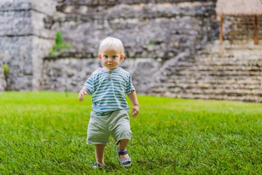 Baby tourist exploring the ancient pyramids of Palenque, Mexico, surrounded by dense jungle. Cultural heritage and adventure travel concept.
