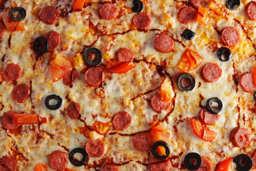 Delight in a mouthwatering pizza adorned with pepperoni slices and black olives, fresh tomato pieces, and a rich swirl of sauce, perfect for any occasion.