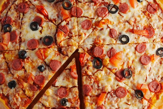 Freshly baked pepperoni pizza, generously layered with olives and tomatoes, emerges golden and crispy, inviting everyone to indulge in a delightful culinary experience.