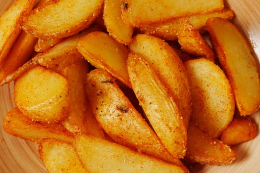 Golden potato wedges, perfectly seasoned and golden, are artfully arranged in a charming bowl