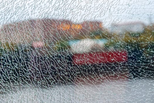 A shattered glass texture beautifully blurs the vibrant colors of the garden beyond, capturing a moment of fractured reflection