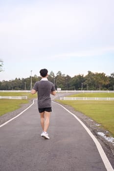 Athletic man jogging in a peaceful park. Fitness and healthy lifestyle concept.