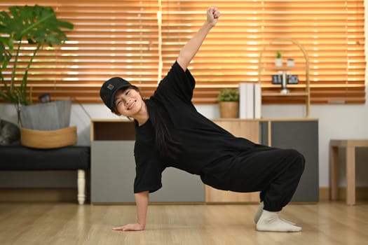 Energetic teenage girl practicing Hip Hop dance at home.