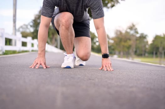 Athlete man in starting position ready for sprint. Goals and motivation concept.