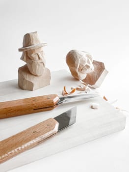 Wood carving artistry. Crafting faces with precision tools and creative skill.