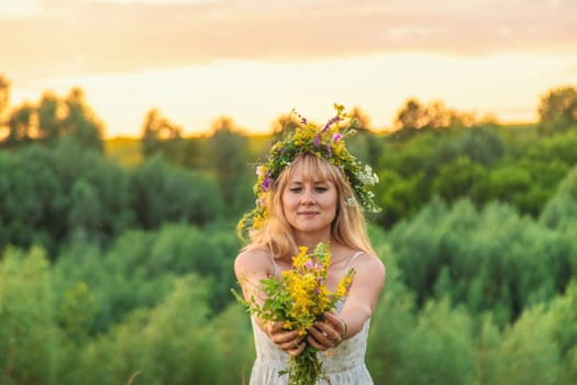 Woman in a meadow with medicinal herbs. Selective focus. Nature.