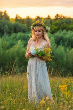 Woman in a meadow with medicinal herbs. Selective focus. Nature.
