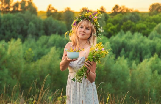 Woman in a meadow with medicinal herbs. Selective focus. Nature.