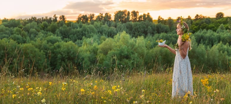 Woman in a meadow with medicinal herbs. Selective focus. Nature.