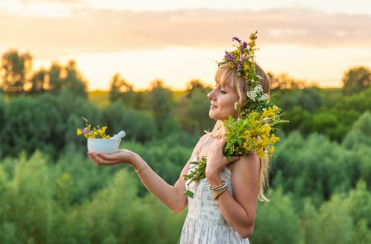 Woman in a meadow with medicinal herbs. Selective focus. Nature.