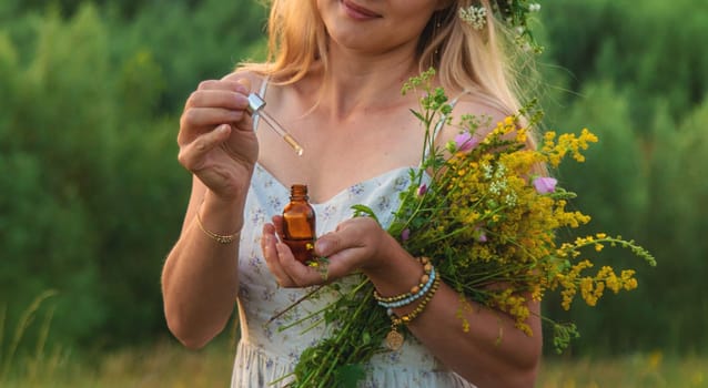 Woman in a meadow with medicinal herbs. Selective focus. Nature.