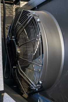 Close-up of a powerful industrial cooling fan operating, ensuring efficient ventilation and temperature control in a professional setting