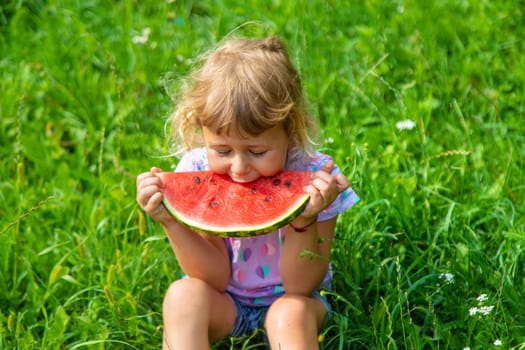 Child eats watermelon in summer. Selective focus. Kid.