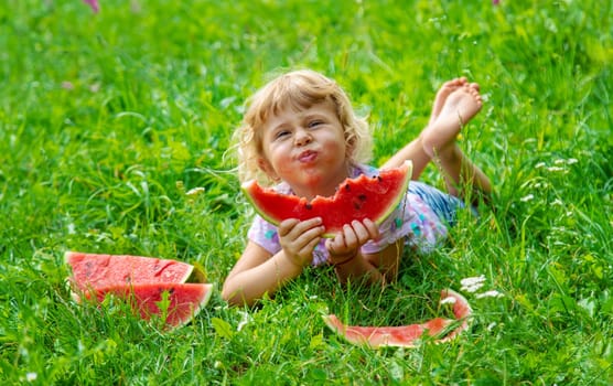 Child eats watermelon in summer. Selective focus. Kid.