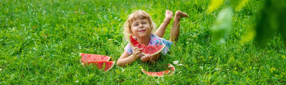Child eats watermelon in summer. Selective focus. Kid.