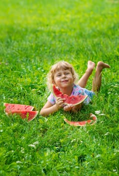 Child eats watermelon in summer. Selective focus. Kid.