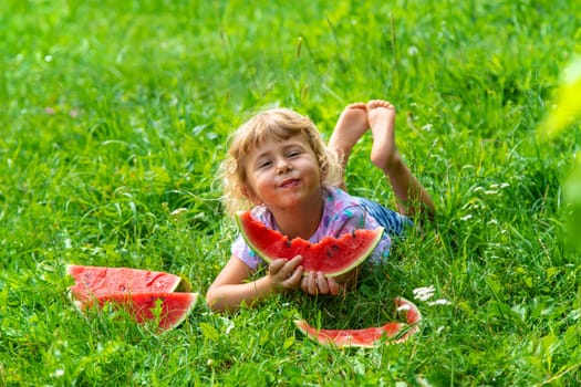 Child eats watermelon in summer. Selective focus. Kid.
