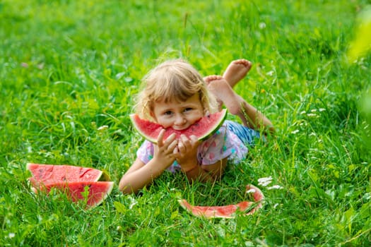 Child eats watermelon in summer. Selective focus. Kid.
