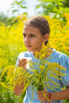 Child in ragweed flowers allergy. Selective focus. Kid.