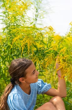 Child in ragweed flowers allergy. Selective focus. Kid.