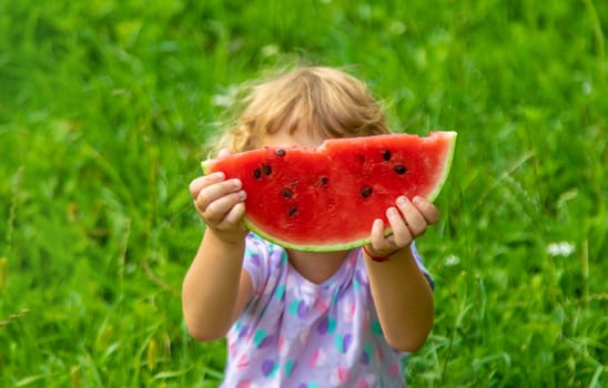 Child eats watermelon in summer. Selective focus. Kid.