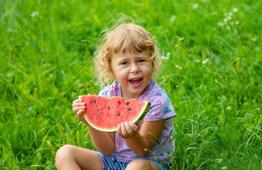Child eats watermelon in summer. Selective focus. Kid.