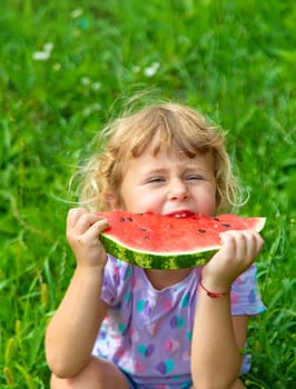 Child eats watermelon in summer. Selective focus. Kid.