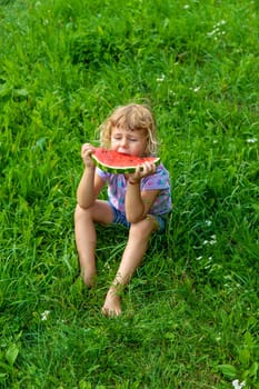 Child eats watermelon in summer. Selective focus. Kid.