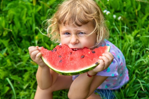 Child eats watermelon in summer. Selective focus. Kid.