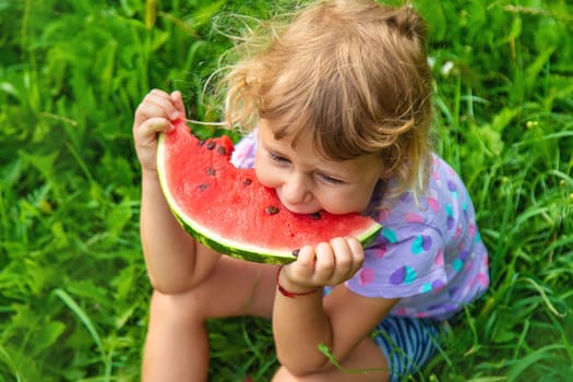 Child eats watermelon in summer. Selective focus. Kid.