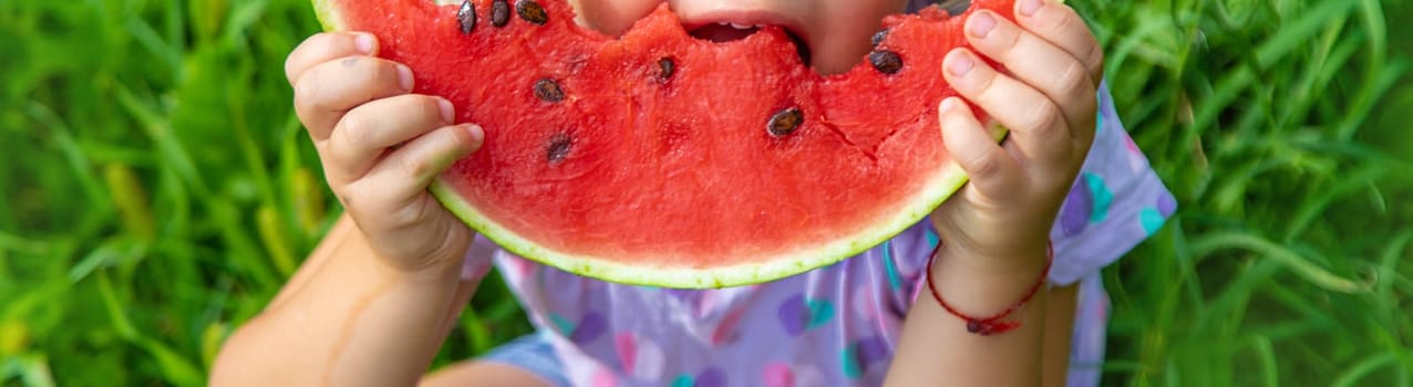 Child eats watermelon in summer. Selective focus. Kid.