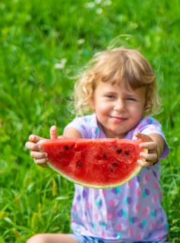 Child eats watermelon in summer. Selective focus. Kid.
